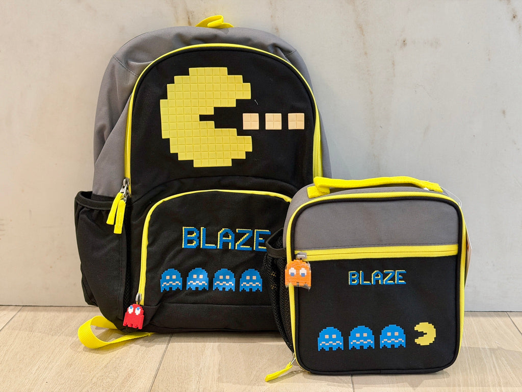 Black and yellow arcade game backpack and matching lunch box, each custom embroidered with the name Blaze in blue pixel letters