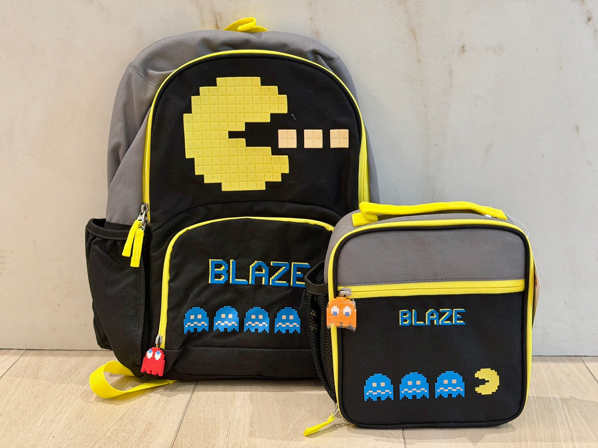 Black and yellow arcade game backpack and matching lunch box, each custom embroidered with the name Blaze in blue pixel letters