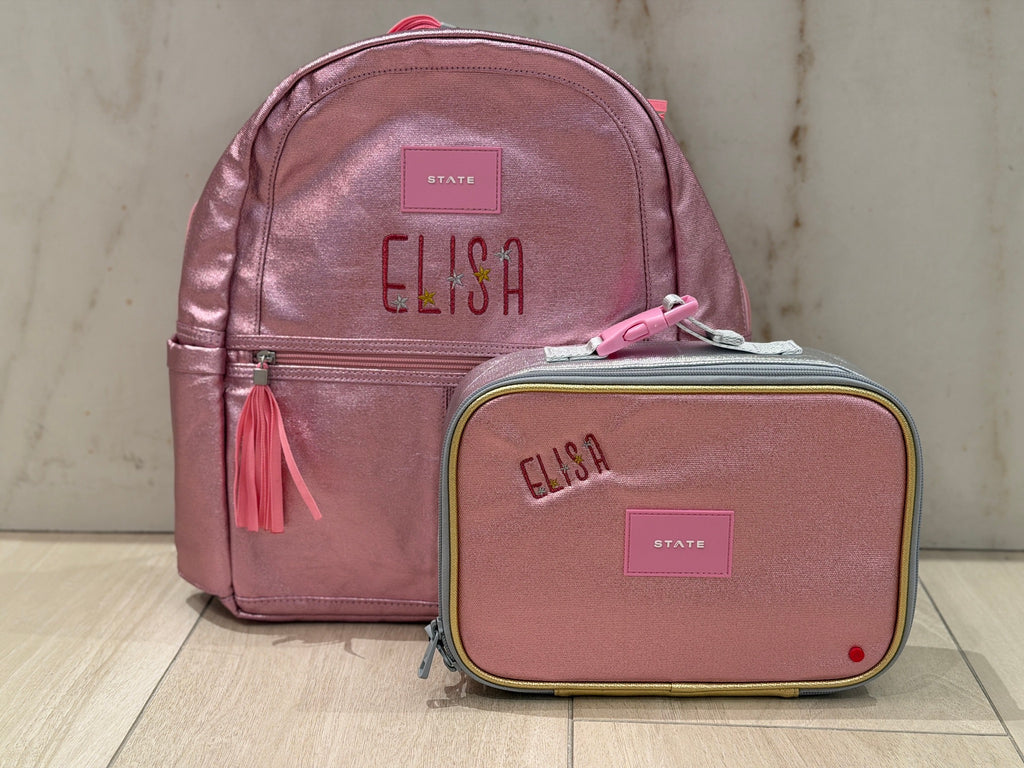 Pink metallic backpack and lunch box set custom embroidered with the name Elisa in red letters with gold and silver stars