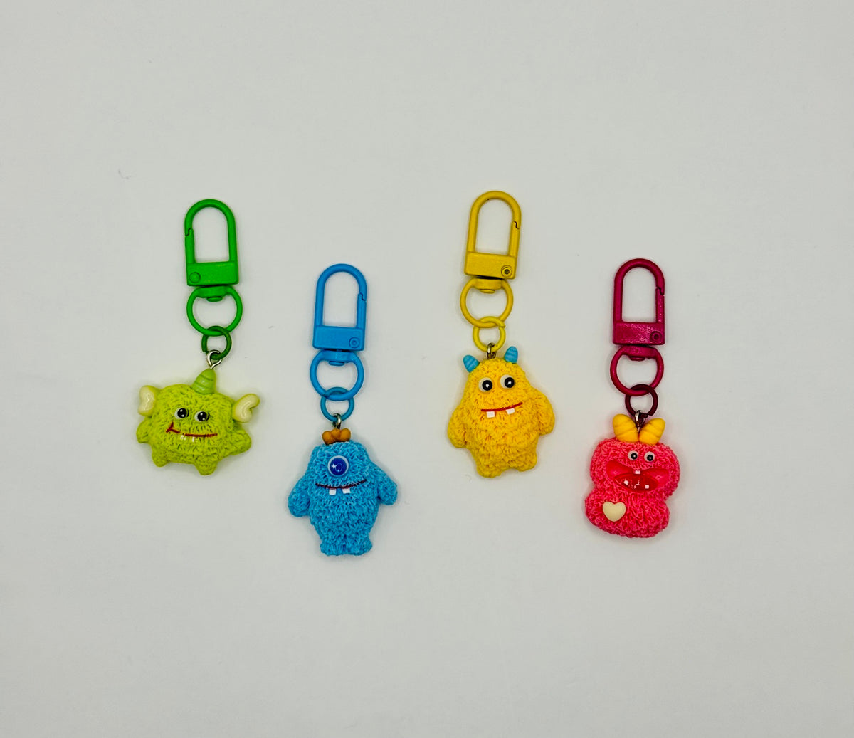Fuzzy Monster charms in green, blue, yellow and pink with matching swivel clasps